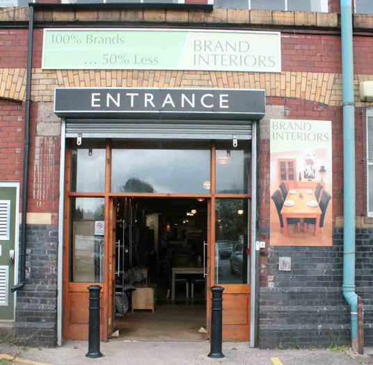 Entrance to a building with 'Brand Interiors' signage and a glass door.